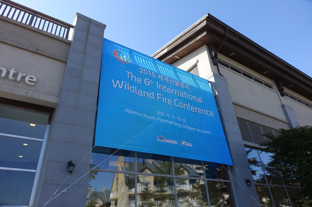 Glaswandelbau mit Lichtern für die 6. Internationale Wildlandbrandkonferenz in Pjöngjang, Nordkorea, mit einem Banner und einem Baum auf der rechten Seite.