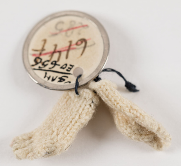 Nahaufnahme eines kleinen Stücks Schafwollstoff mit einem daran befestigten Etikett, auf dem likely der Wool-Typ angegeben ist.