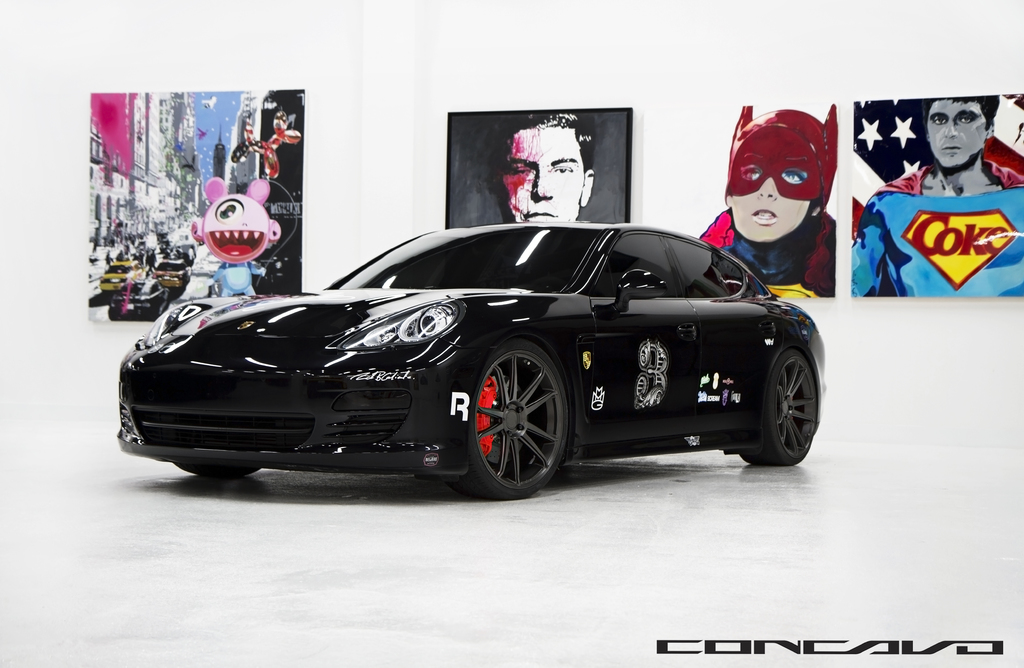 Ein schwarzer Nissan-Sportwagen ist zusammen mit Cartoon-Postern im Hintergrund und einem kleinen Zitat am unteren Rand des Bildes zu sehen.