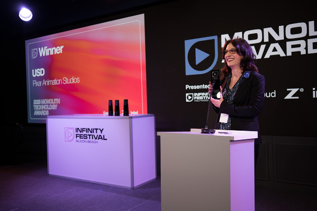 Frau in einem schwarzen Kleid, die eine Auszeichnung auf einem Podium mit einem Mikrofon hält, während der Monolux Awards 2020.