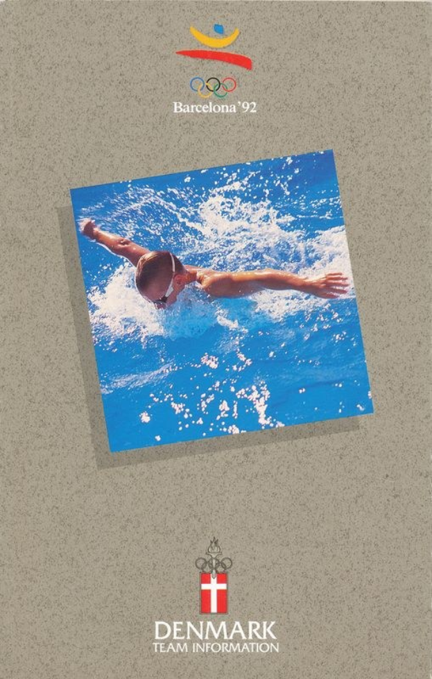 Plakat mit einem Schwimmer in einem blauen Anzug mit ausgestreckten Armen im Wasser, unter dem Logo der Olympischen Spiele 1992 in Barcelona und dem Text 'Denmark Team Information', vor einem hellblauen Himmel mit weißen Wolken.
