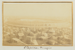 Altes Schwarz-Weiß-Foto eines Stadions umgeben von Stadtgebäuden, Bäumen und Strommasten mit Text unten.
