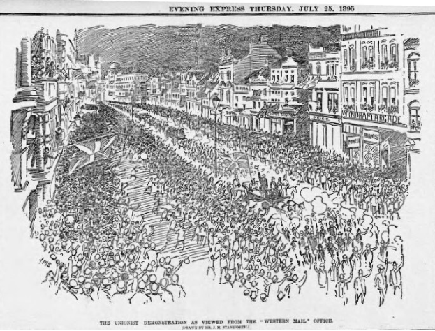Schwarze und weiße Zeichnung einer Menge, die eine von Gebäuden gesäumte Straße entlanggeht, mit Text oben und unten, der 'Die Unionistendemonstration, wie sie vom Western Mail Office aus gesehen wird' lautet.