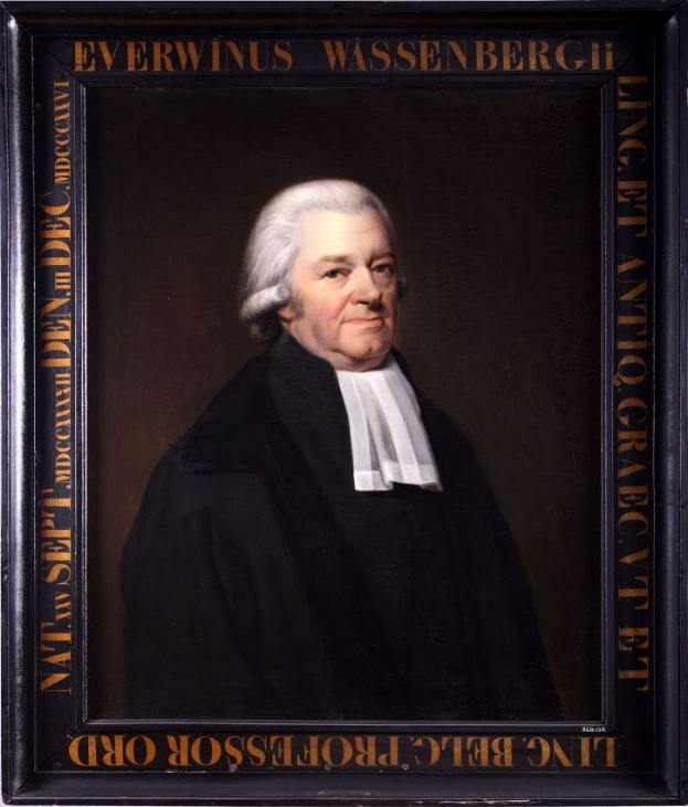 Portrait eines Mannes in einer schwarzen Robe, eingerahmt mit Text, der ihn als Anwalt identifiziert, sitzend mit gefalteten Händen und einem ernsten Gesichtsausdruck.