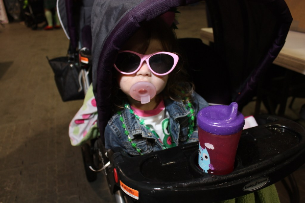 Kind sitzt in einem Walker auf der Straße.