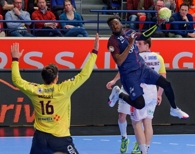 Eine Gruppe von Männern spielt Hallenfußball auf einem Court mit einem Ball in der Luft, und Zuschauer im Hintergrund schauen dem Spiel zu, mit einer Tafel, auf der "Futsal-Weltmeisterschaft 2019 - Paris Saint-Germain vs Bordeaux" steht.