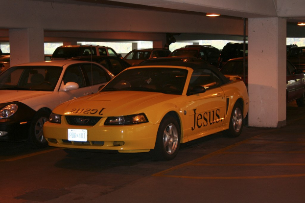 Vollgestellter Parkplatz mit zahlreichen Autos vor einem Gebäude