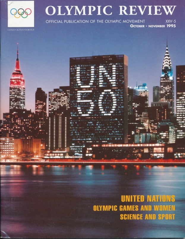 Ein Buch mit dem Titel "Olympische Spiele: Offizielle Veröffentlichung der Olympischen Bewegung" mit einer Stadtansicht auf dem Cover, die Gebäude, Lichter und Wasser zeigt, auf einer flachen Oberfläche.