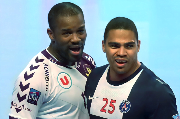 Zwei Männer in weißen und blauen T-Shirts auf einem Fußballfeld, die einen Sieg feiern.