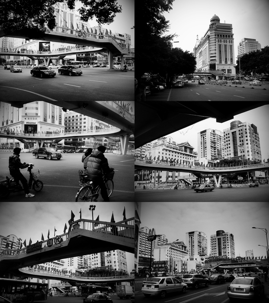 Autos und Fahrräder unter einer Brücke mit wenigen Fahrzeugen vor einem Gebäude