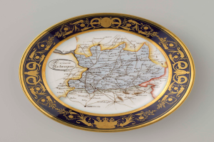 Ein weißes Kennzeichen mit einer detaillierten Deutschlandkarte, verziert mit kunstvollen Designs und Text.