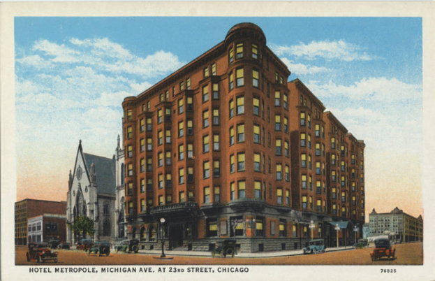Eine alte Postkarte zeigt das Hotel Metropole in Chicago, Illinois, ein großes Gebäude mit vielen Fenstern, umgeben von anderen Gebäuden, Straßenlaternen, Autos, Bäumen und einem bewölkten Himmel, mit Text am unteren Rand.