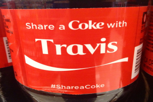 Eine Coca-Cola-Flasche mit dem Aufdruck "Teile eine Coke mit TRAVIS".